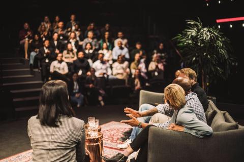 Panel of professionals on stage discussing in front of audience